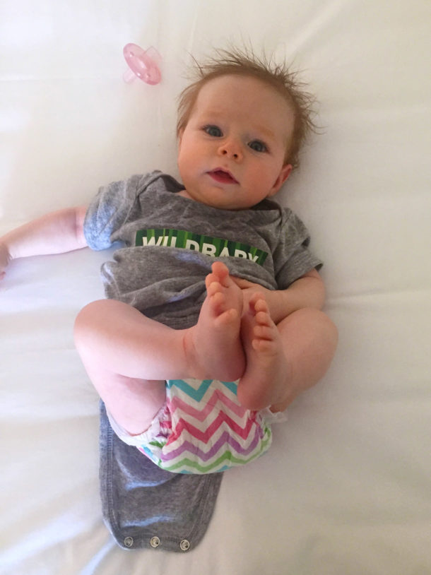 Photo of a baby in a onesie with "Wildbaby" across the front. Photo of a baby in a onesie with "Wildbaby" across the front.