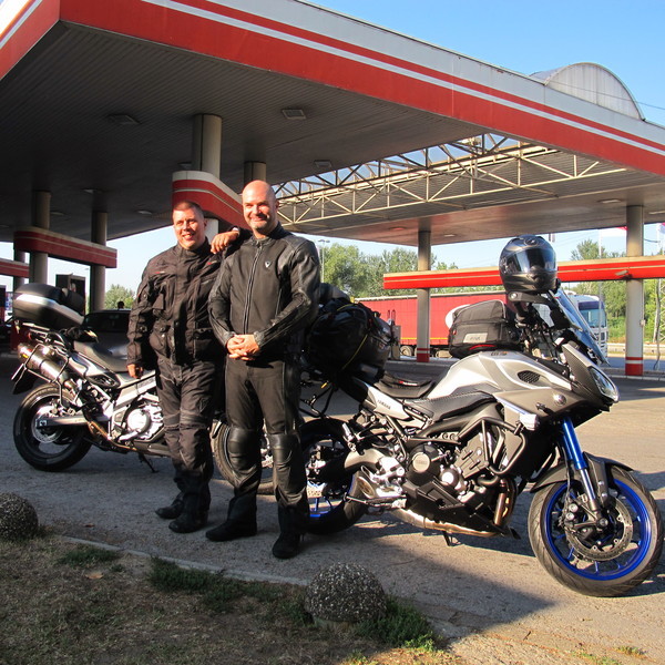 Photo of Milan and his friend standing by their motorcycles. Photo of Milan and his friend standing by their motorcycles.